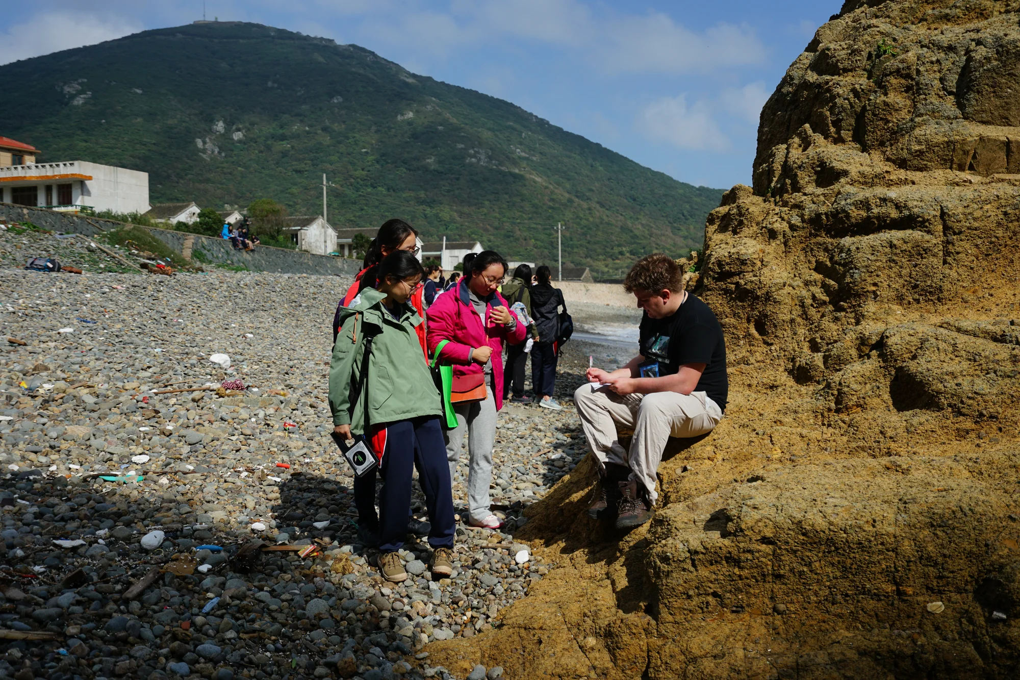Students and teacher on a beach doing coastal studies data collection