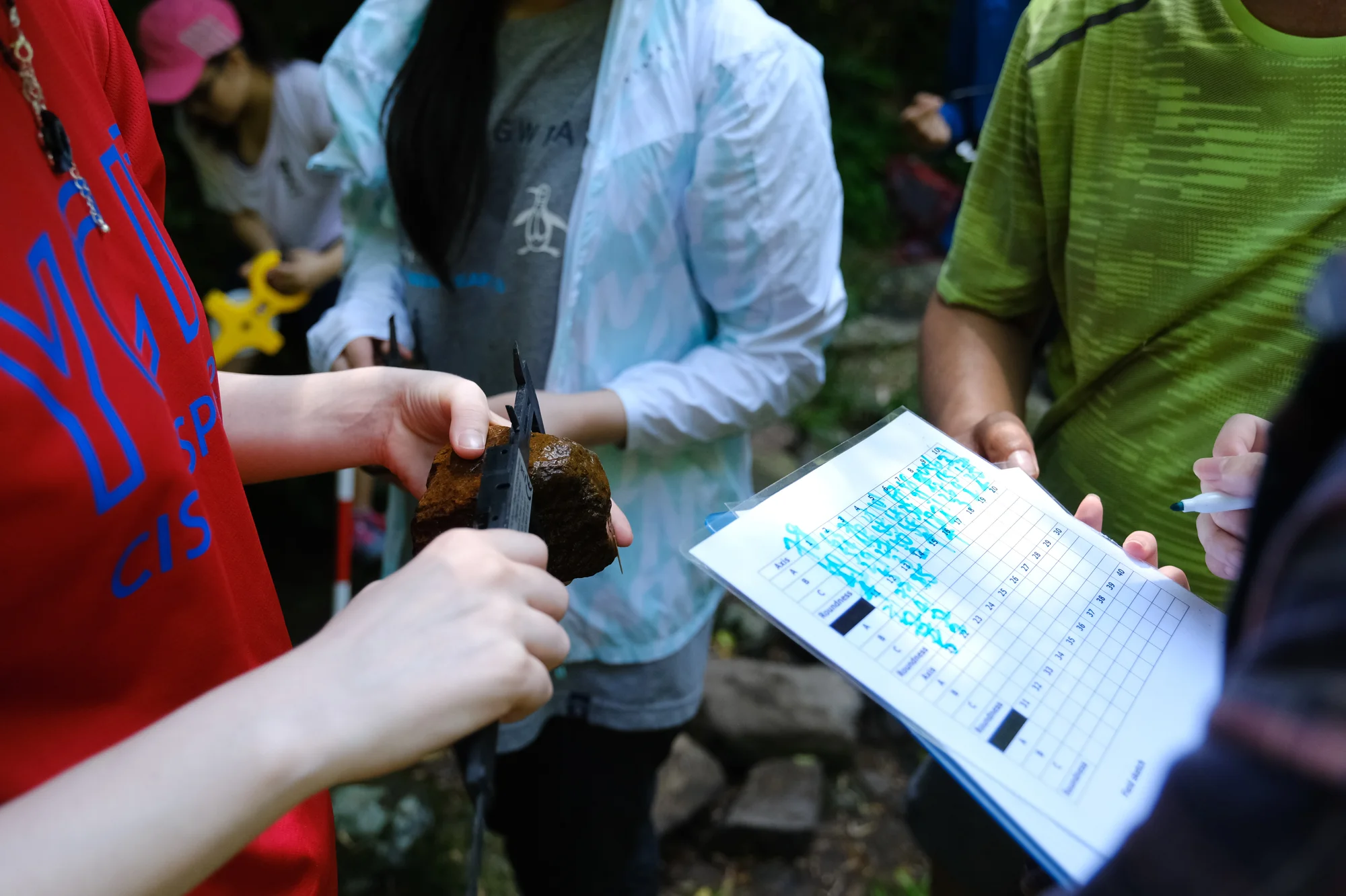 River studies data collection, students checking the bed load