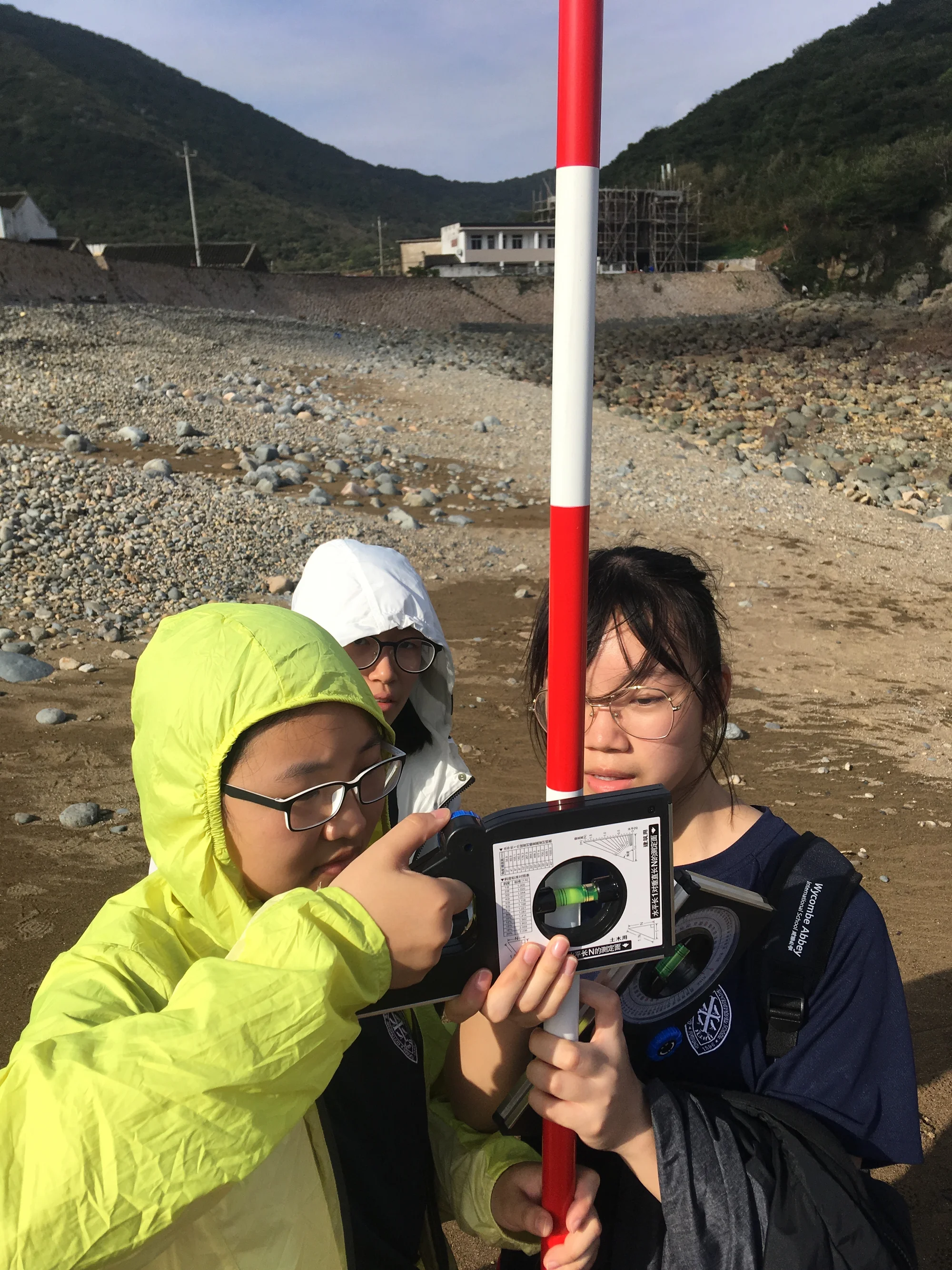 3 students colleting coastal studies data on a beach