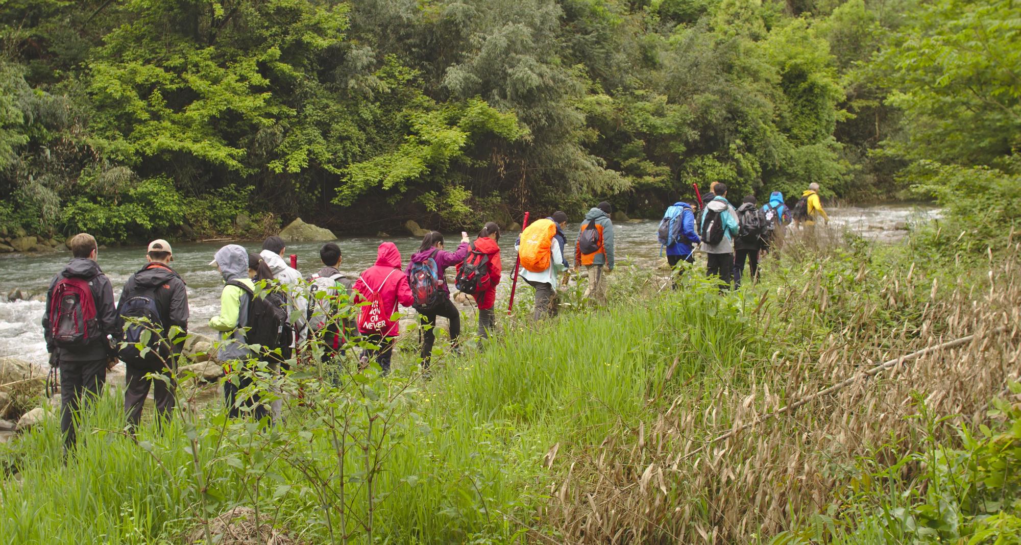 River Studies in China, students walking by a river with equipment
