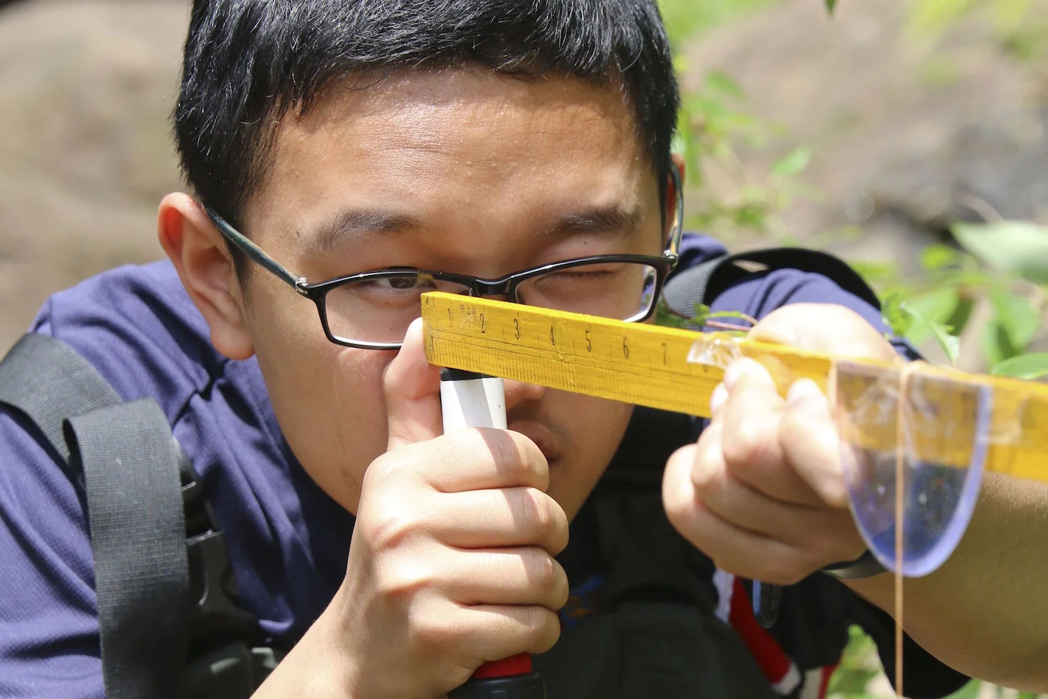 Student using hand made clinometer, Zen Quest Adventures